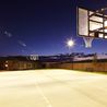 Lighted full-size basketball court at dusk