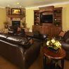 Clubhouse lounge with leather seating, stone fireplace, and entertainment center
