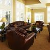 Bright clubhouse sitting area with leather furniture and tall windows