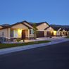 Townhomes with lit porches and garages at dusk