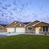 Single-level townhome with two-car garage and green lawn at dusk
