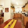 Dining area open to a kitchen with wood cabinets and ceiling fan