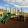 Playground with green slides on a mulch play area